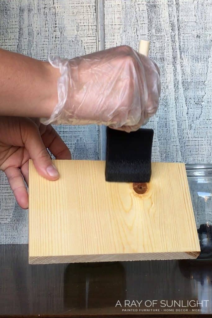 brushing DIY weathered wood stain onto wood