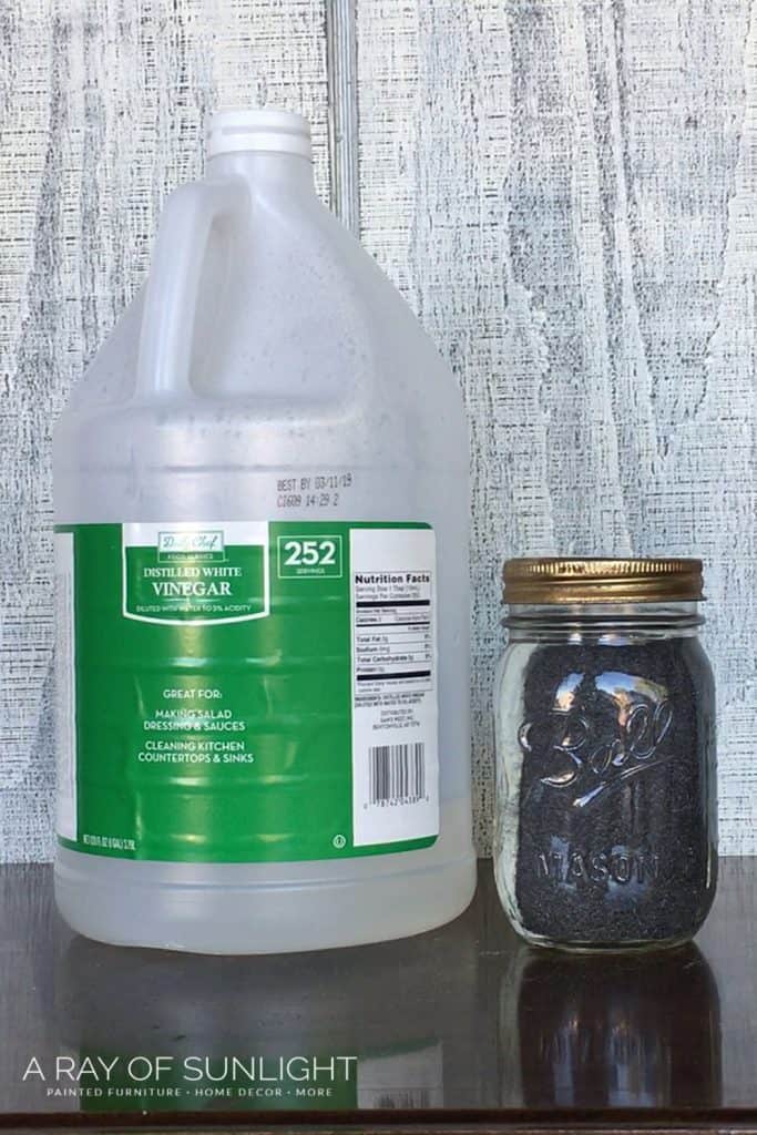 Gallon of white vinegar and mason jar with steel wool and vinegar inside