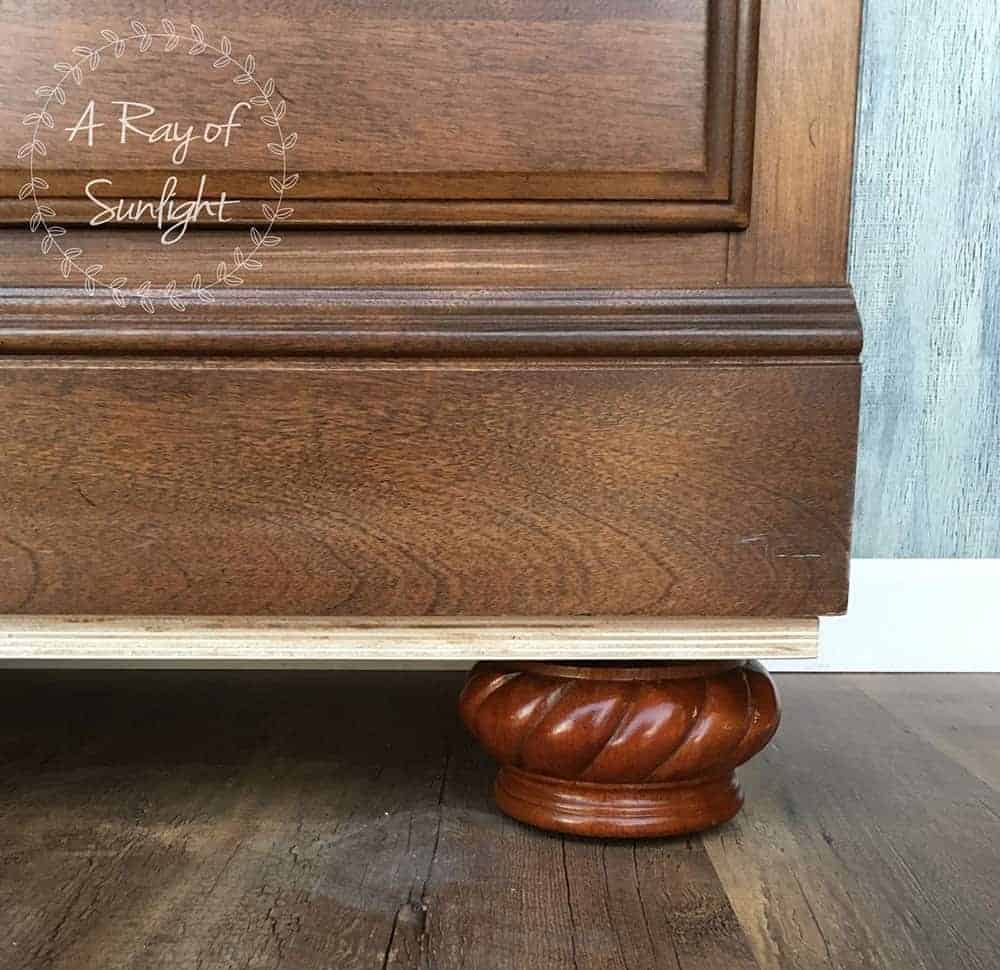 closeup of plywood with bun feet added to bottom of nightstand
