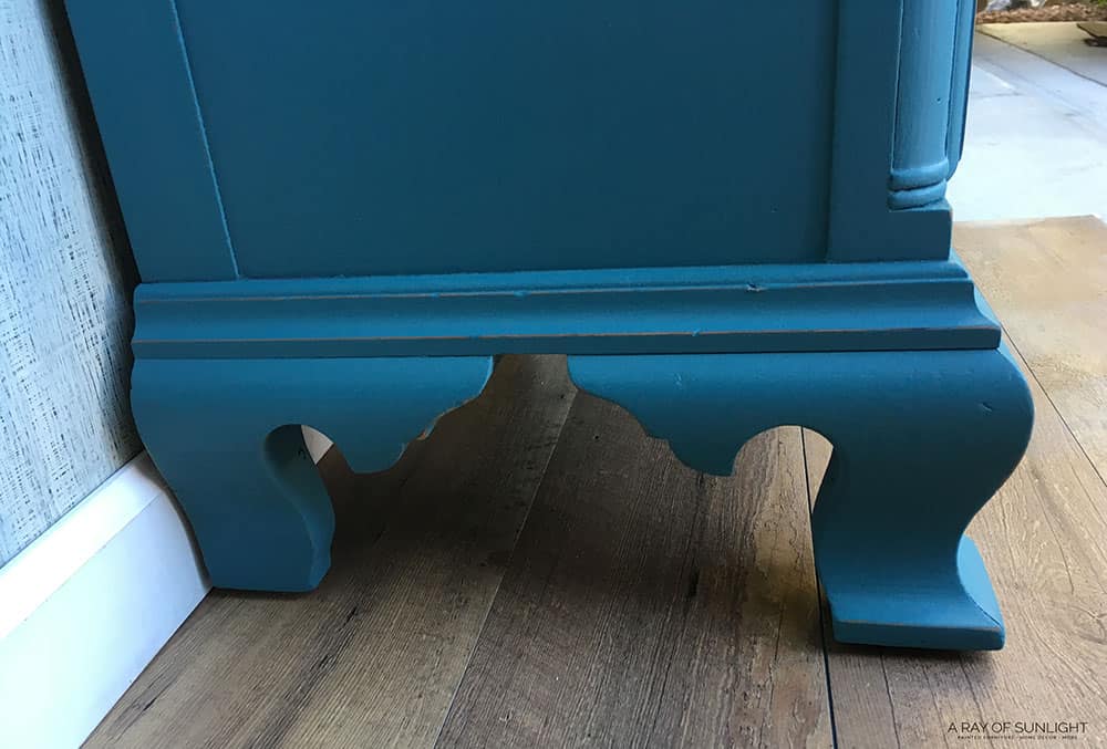 closeup of legs of blue painted nightstand