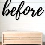 A wooden coffee table sits against a white shiplap wall