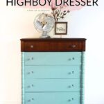 A teal-painted highboy dresser with a dark wood top with clear knobs