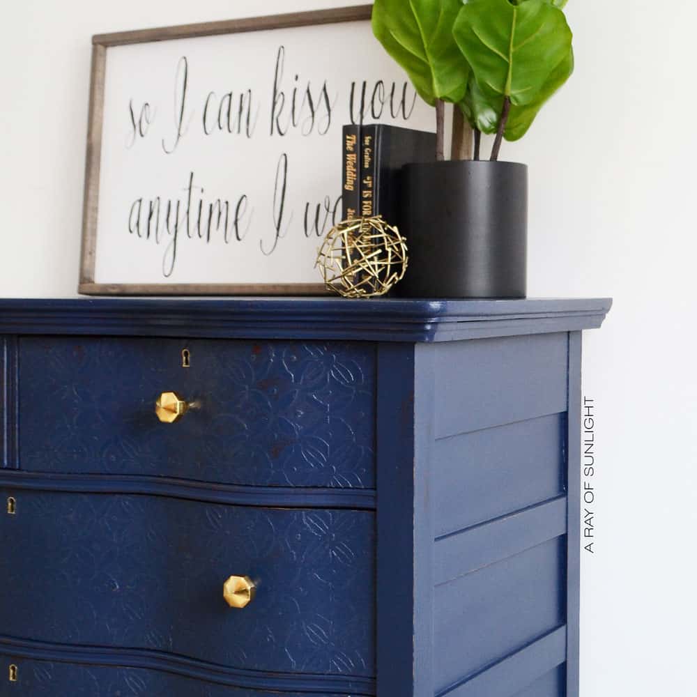 side angle of navy blue dresser with embossed drawers