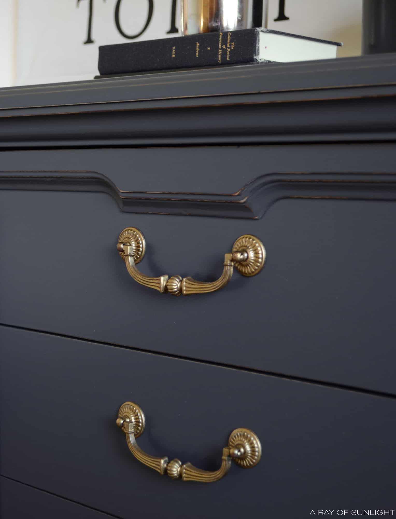 closeup of grey dresser with gold hardware