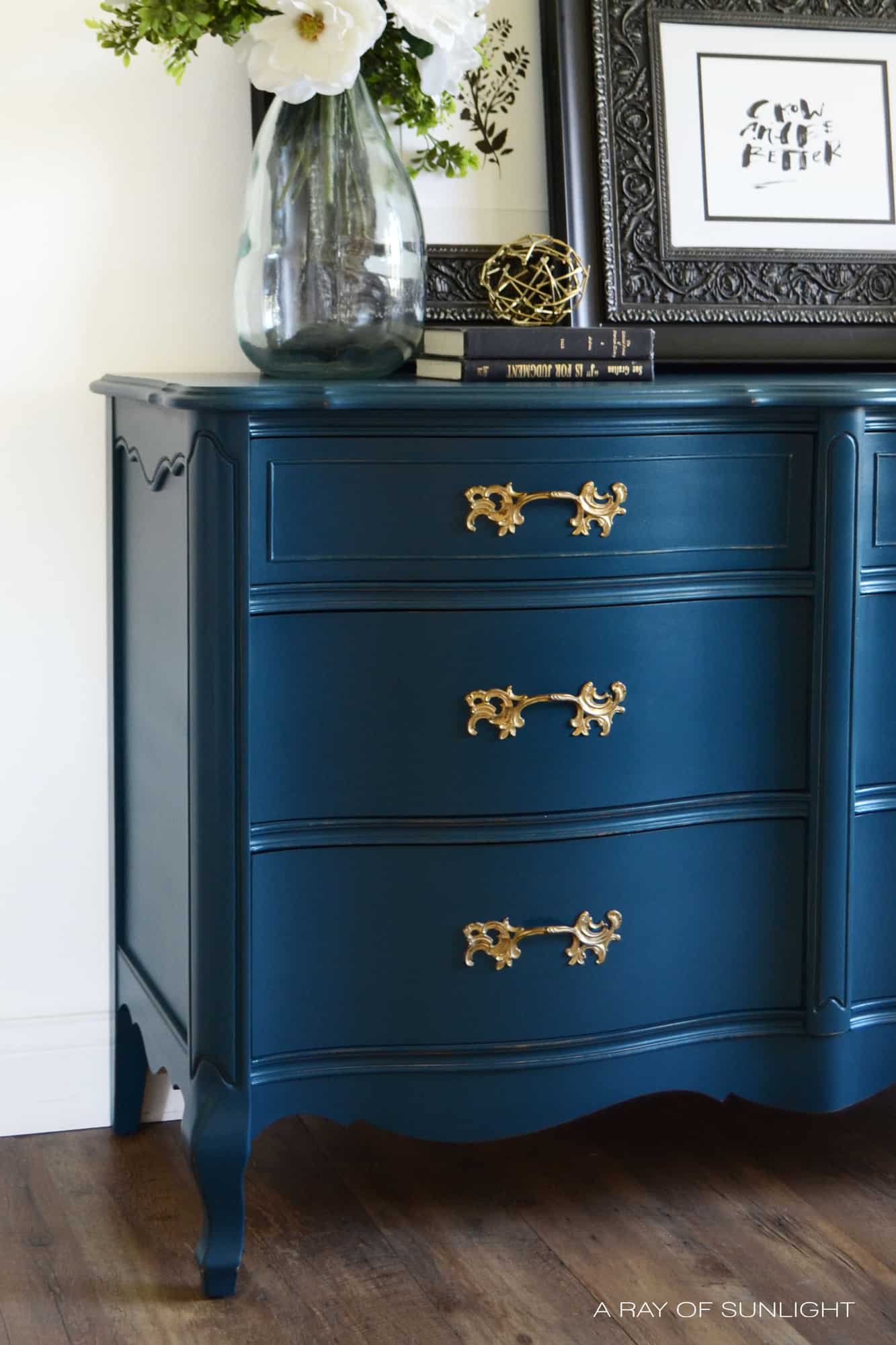 Learn how to create this navy blue finish with antique gold hardware for your own DIY furniture makeover. Painted in Country Chic Paint with the best affordable paint sprayer for refinishing furniture. By A Ray of Sunlight #paintedfurniture #navydresser #furnituremakeover #countrychicpaint #DIYfurniture