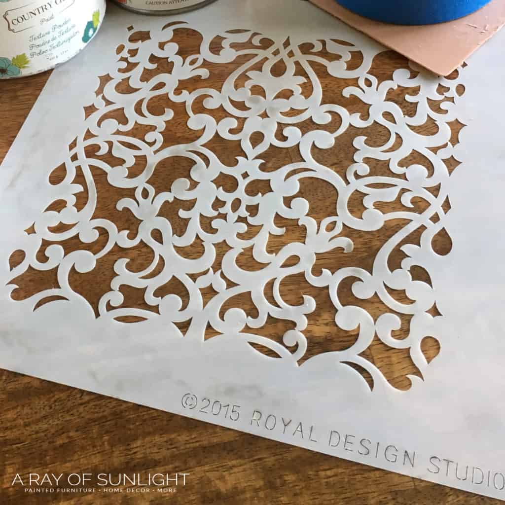 Stencil design laid out before using it on a dresser.