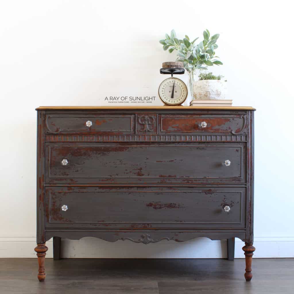 Full view of gray chippy milk painted dresser with clear hardware knobs