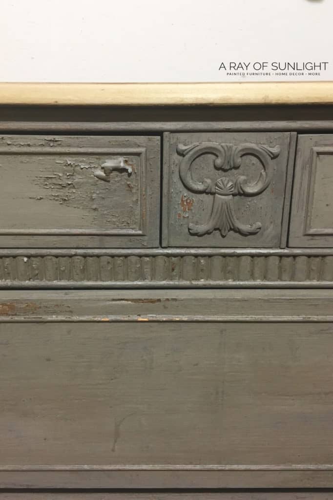 Close view of milk paint starting to chip on a dresser