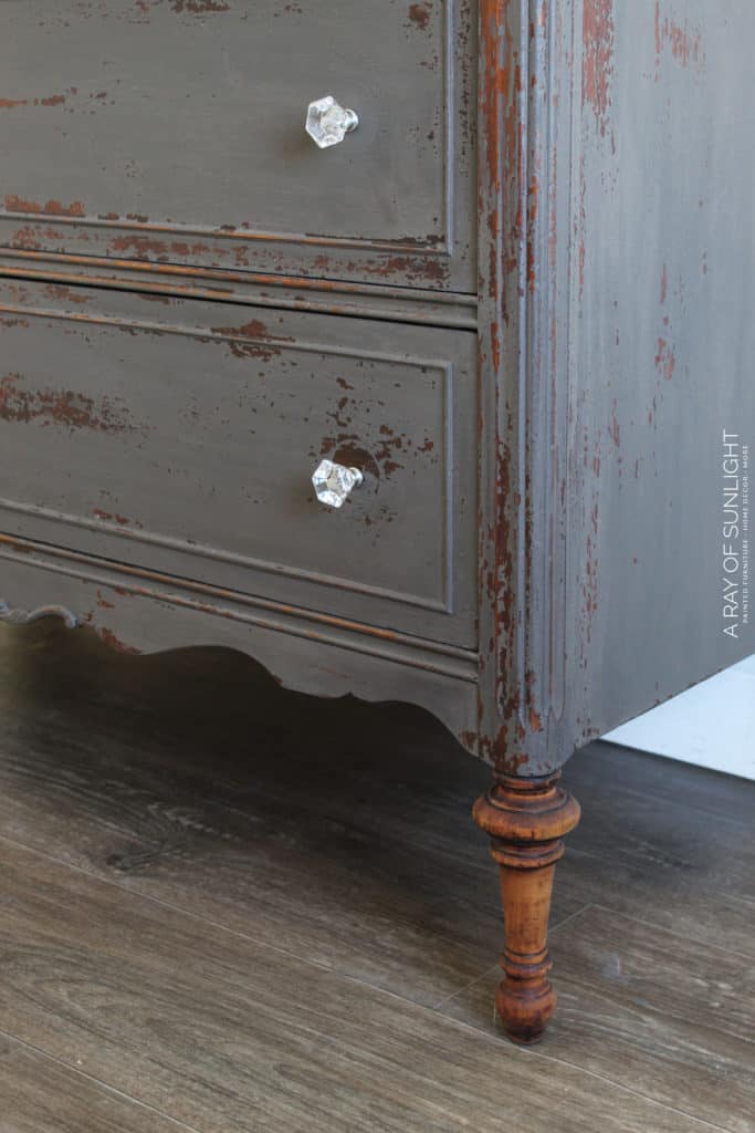 How to Use Powdered Milk Paint on your thrifted, old bedroom dresser to create an old worn farmhouse style look. The warm gray milk paint chipped and left the old wood finish showing underneath in some places. The top and legs were sanded down to bare wood and sealed with Hemp Oil. 