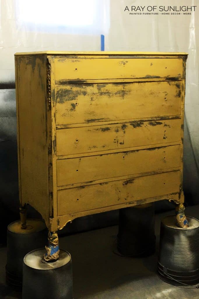 dresser in paint booth painted yellow with chippy finish