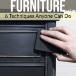 Hand sanding the edge of a dark wooden drawer; text reads Distressing Furniture: 6 Techniques Anyone Can Do.