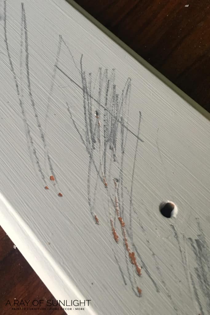 Gray scratches on painted dresser drawer after scratched with keys