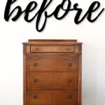 A vintage wooden dresser stands against a white wall with before written above in large script.