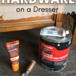 Tube of wood filler, can of body filler, and furniture marker on the floor in front of a wooden dresser.
