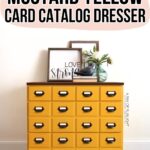 Mustard yellow card catalog dresser with black handles, decor on top, and a Love Strong sign in the background.