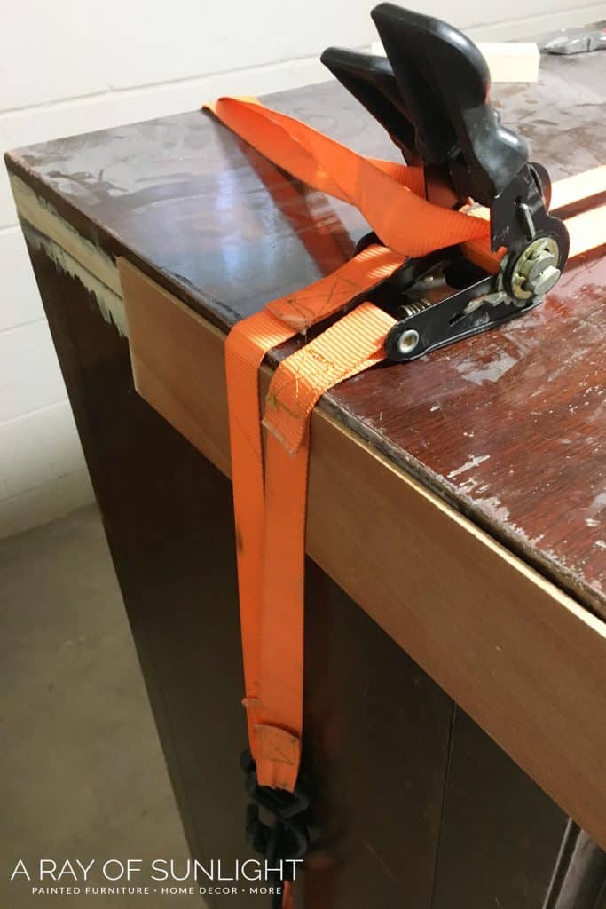 wrapping dresser with tie-down straps to clamp down on veneer
