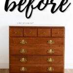 A wooden dresser with brass handles against a white wall, labeled before in large script.