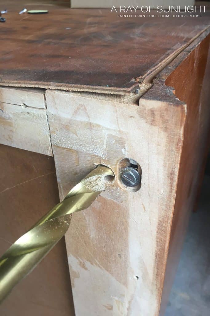 drilling a hole into the bottom of a dresser