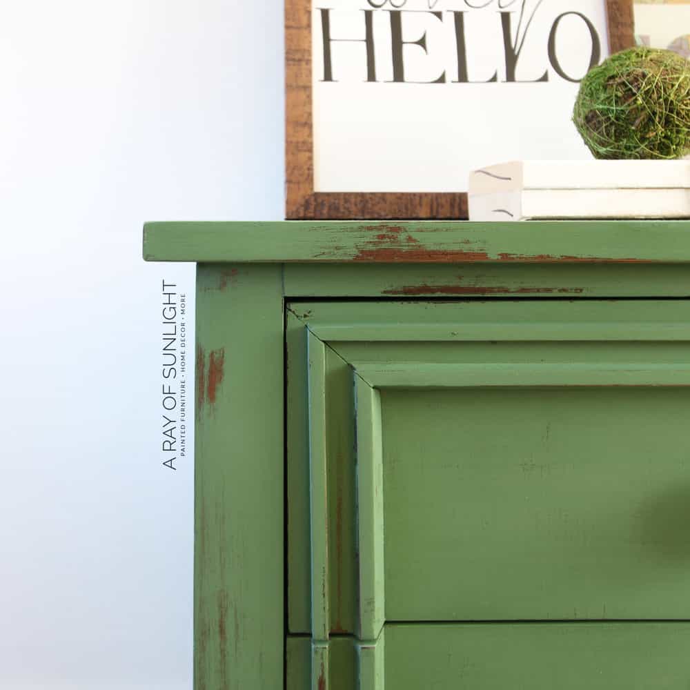closeup of nightstand with green chippy milk paint