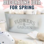 A galvanized bucket labeled Flowers & Garden with spring craft supplies and a glue gun nearby.