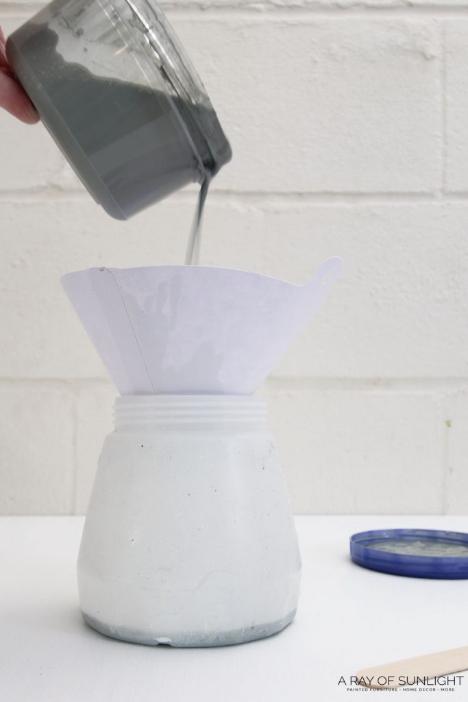 pouring milk paint through paint filter into paint sprayer container