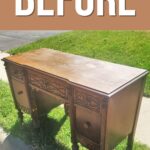 old desk with scratches pictured outside on a grassy floor