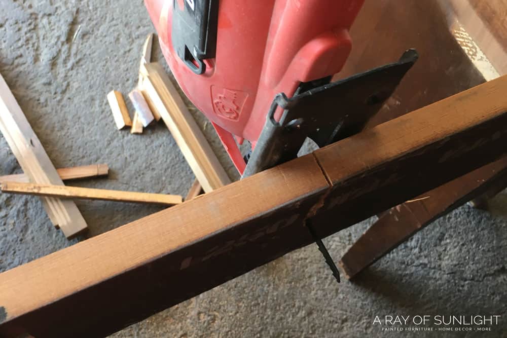 using a jigsaw to cut the back of a desk into two nightstands