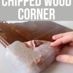 A hand molds putty onto a chipped corner of a wooden surface to repair it.