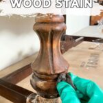 A gloved hand removes wood stain from a carved table leg; text reads How to Remove Wood Stain.