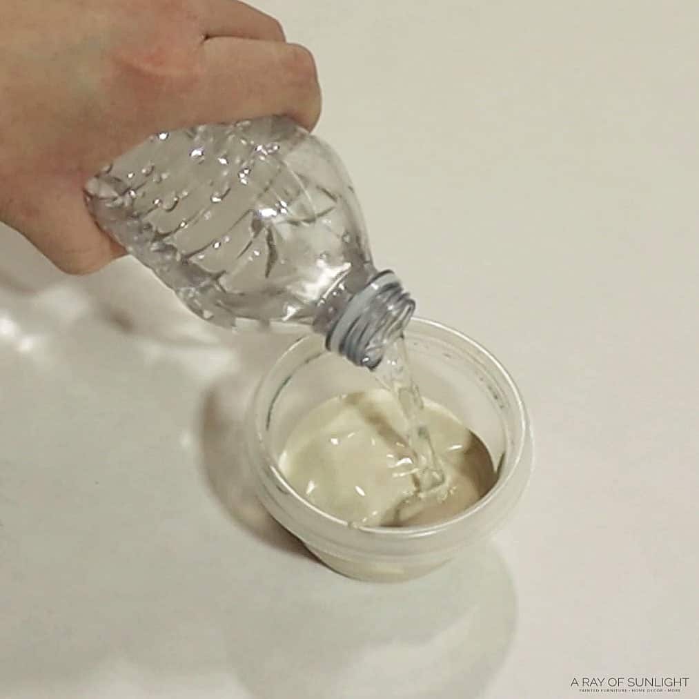 pouring water into fusion mineral paint to make whitewash