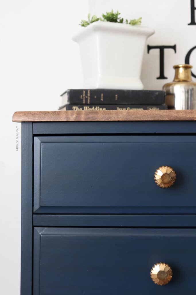 Closeup of navy blue dresser with dark glaze
