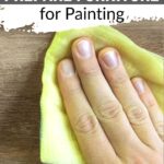 Hand wiping wooden surface with yellow cloth, captioned How to prepare furniture for painting.