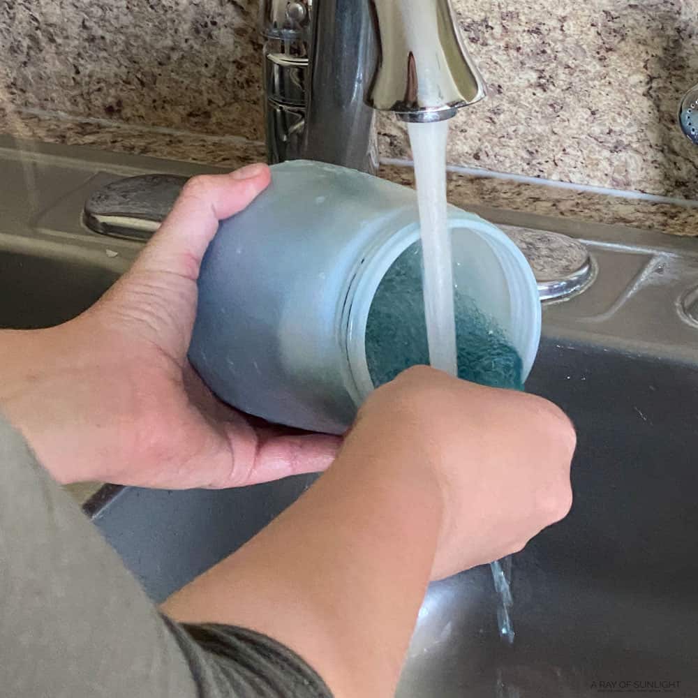 cleaning the paint sprayer container in a sink