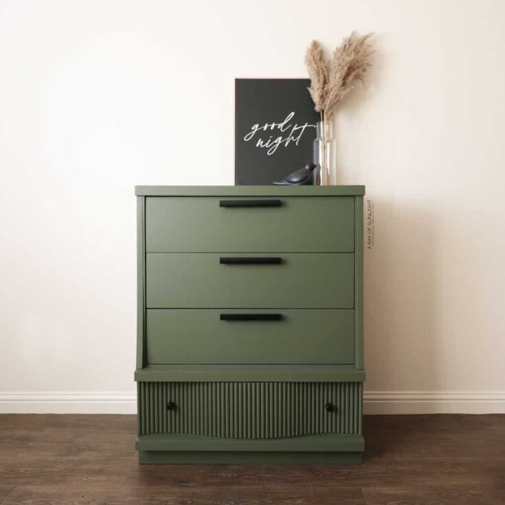 dresser painted green with added dowels at the bottom drawer