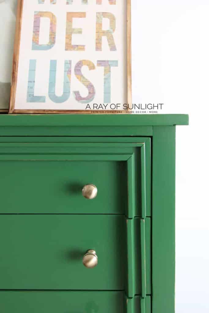 Close view of gold hardware on a green painted modern dresser