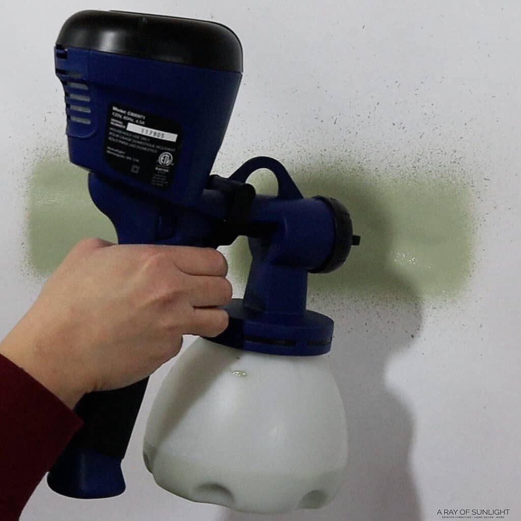 spraying thick chalk paint with homeright sprayer onto white paper