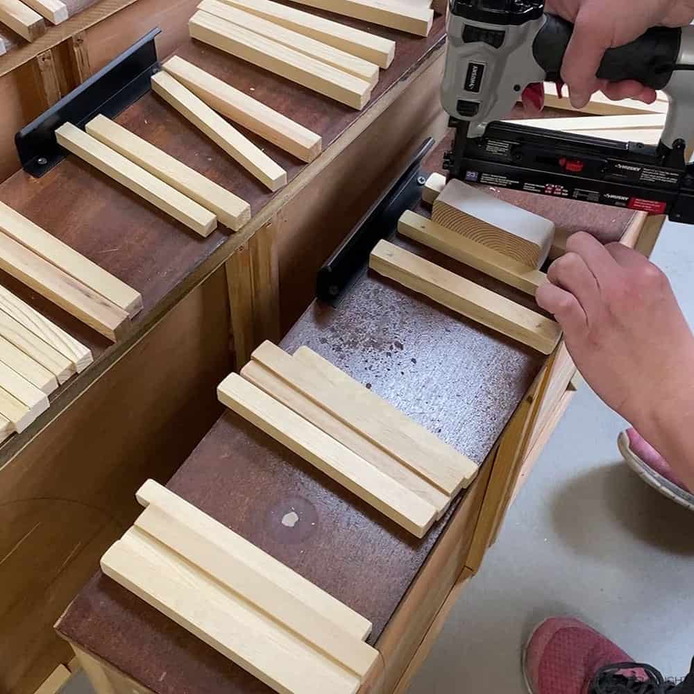 attaching wooden square dowels to the drawers with a pin nailer