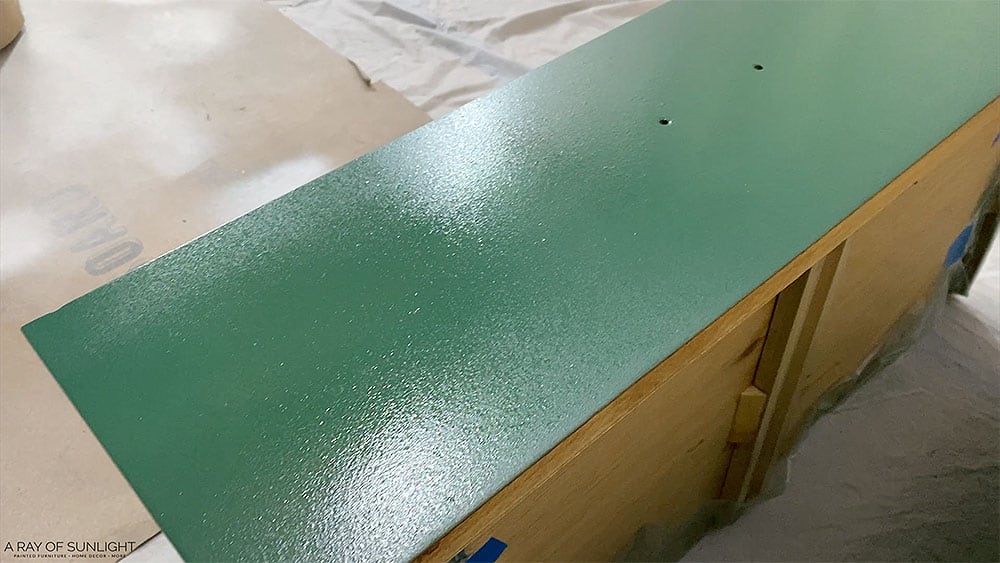 Wet paint on a dresser drawer after spraying the first coat