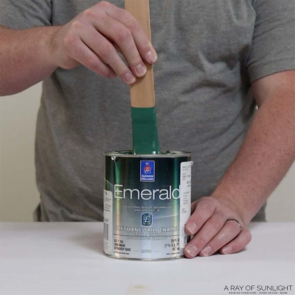 Using a stirring stick to mix Sherwin Williams Emerald Urethane Trim Enamel Paint.