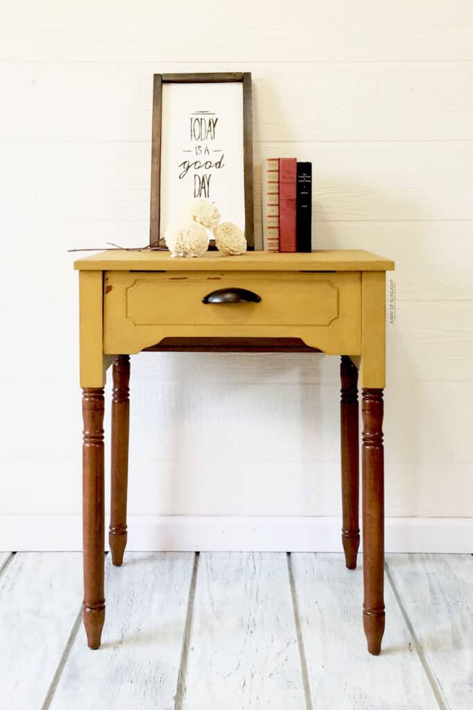 chippy mustard yellow painted sewing table with wood stained legs