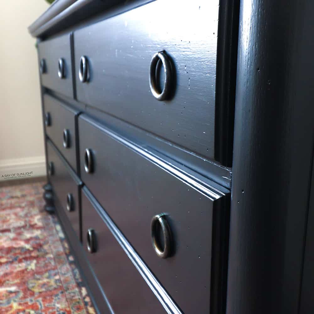 Side angle view of newly painted black dresser.