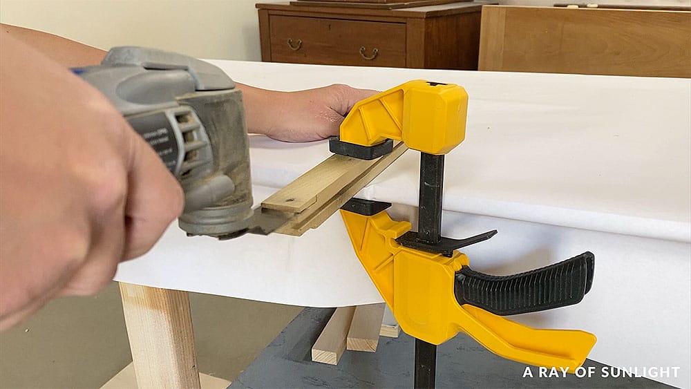 Cutting a notch in the end of a drawer track on a dresser.