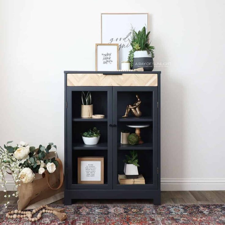 full photo of dark grey cabinet styled with modern decor, and basket and a rug