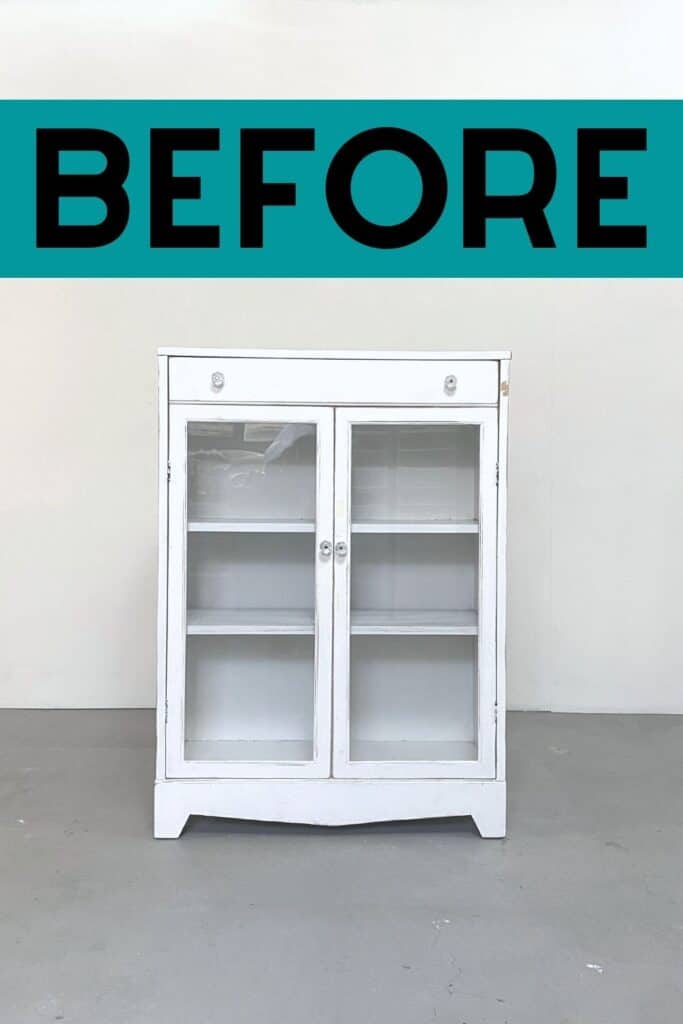 White thrifted cabinet with glass doors and a drawer on top