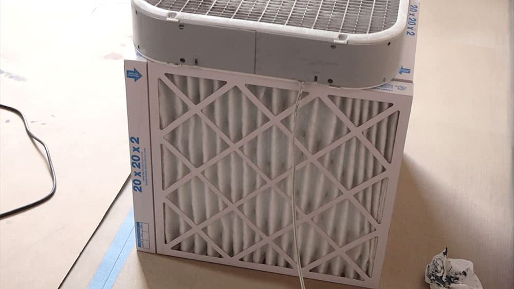 paint booth filter with 4 air filters taped together in a square with a fan on top