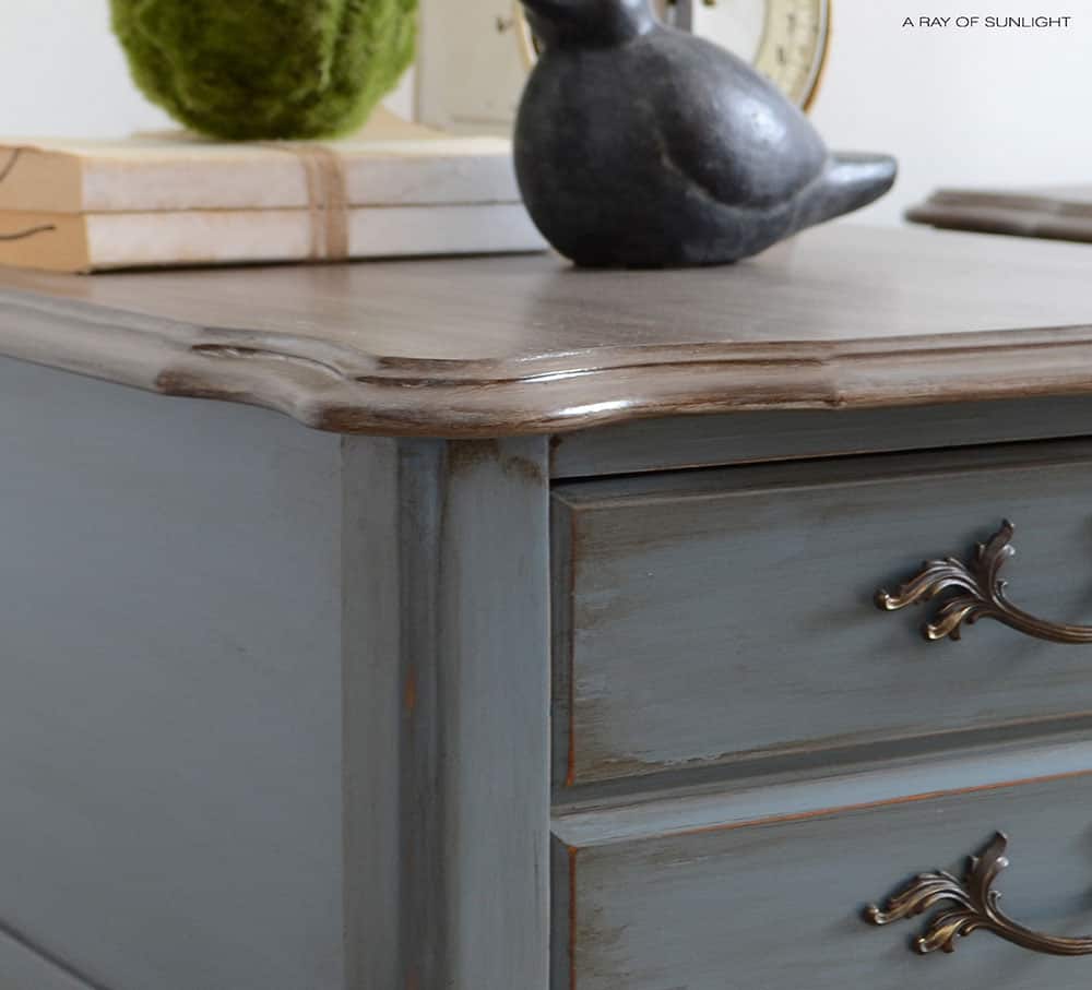 closeup of the blue french provincial nightstand finished with brown glaze and weathered wood top