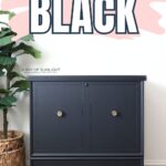 A black tall cedar chest with wooden legs; text above reads Painting Furniture Black.