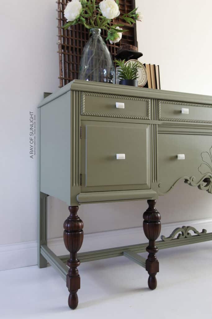 antique buffet after painted in olive green paint with dark wood legs and white knobs