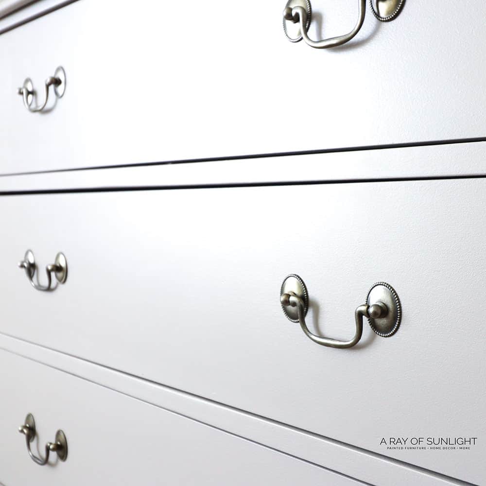Closeup view of cream painted drawers and old hardware
