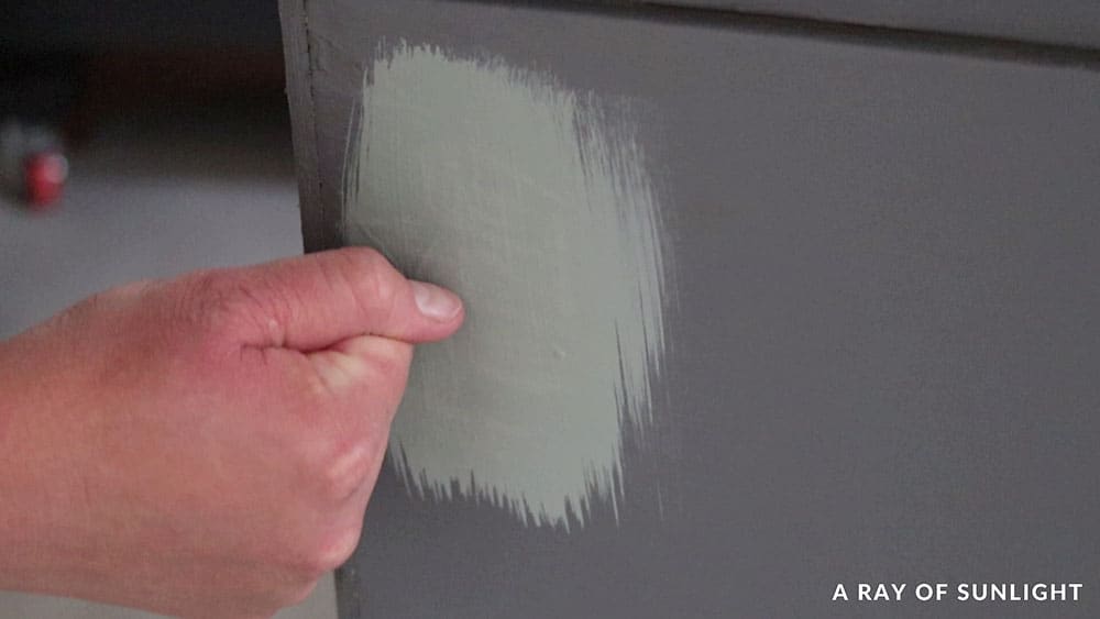 Testing a sample of the paint on the back of cabinet with fingernail scratch test